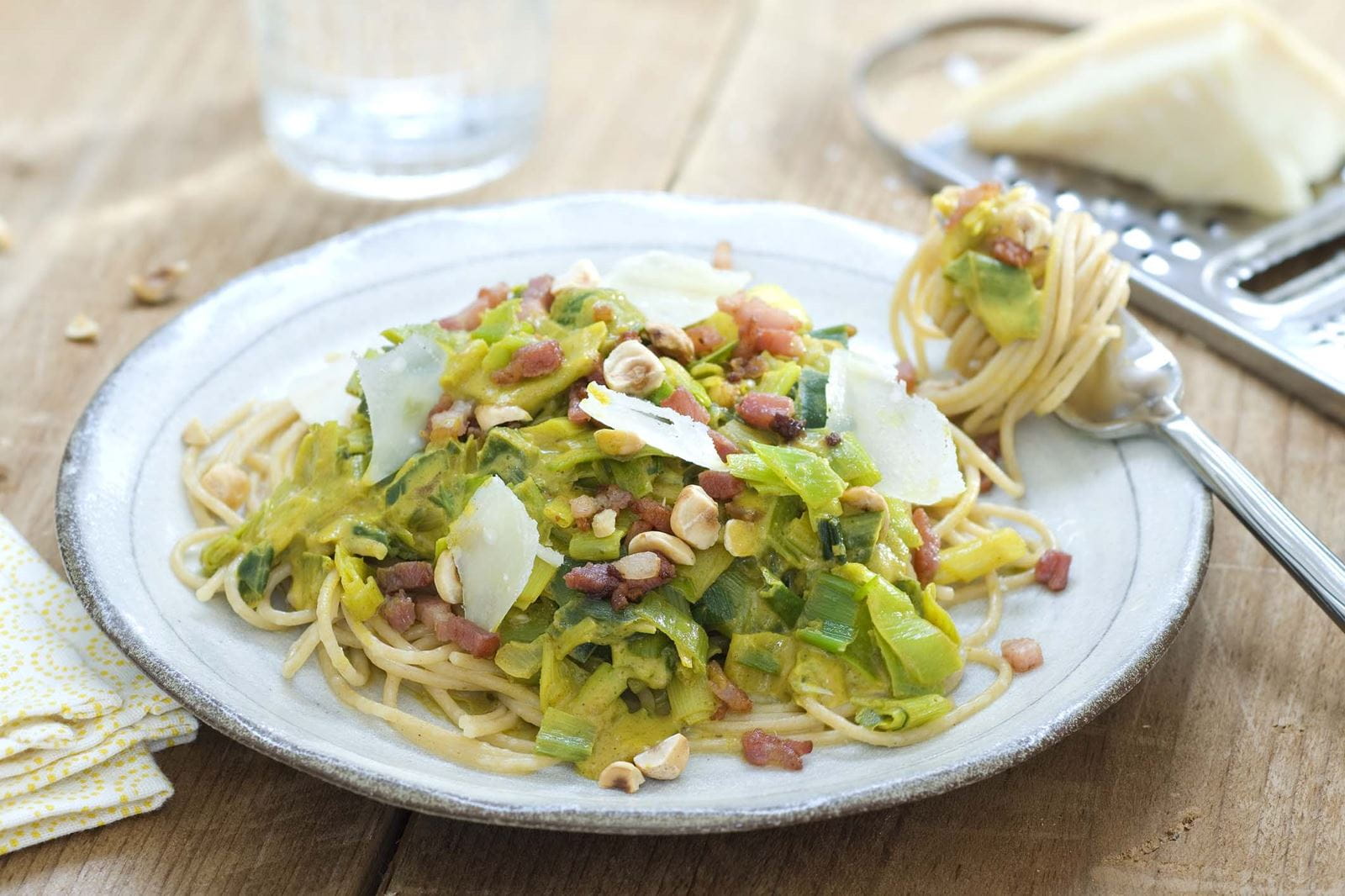 recipe image Spaghettis à la sauce aux poireaux crémeuse, lardons et noisettes