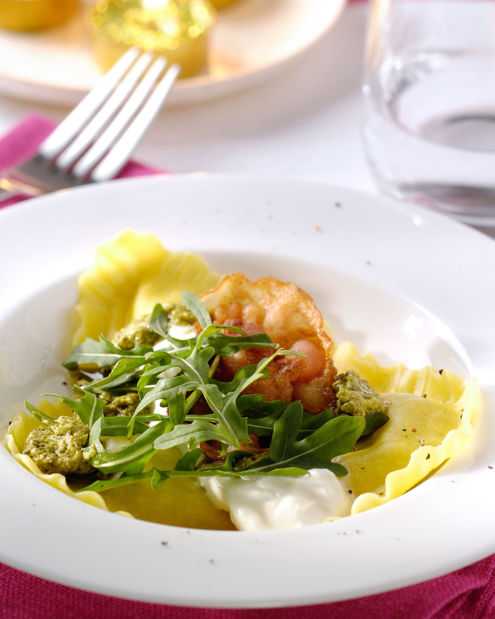 recipe image Grote ravioli met pesto, mascarpone, krokante spek en rucola